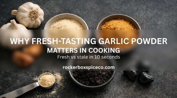Overhead shot of garlic powder in pinch bowls with garlic cloves on a dark kitchen counter.